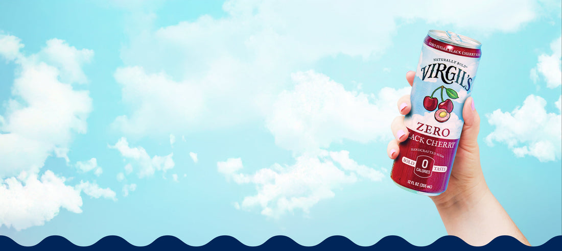 hand holding virgil's zero sugar lack cherry soda in front of sky with clouds